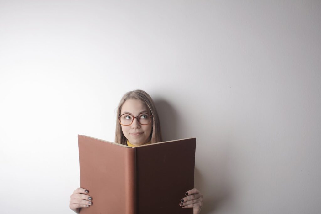 young thinking woman reading book with empty cover